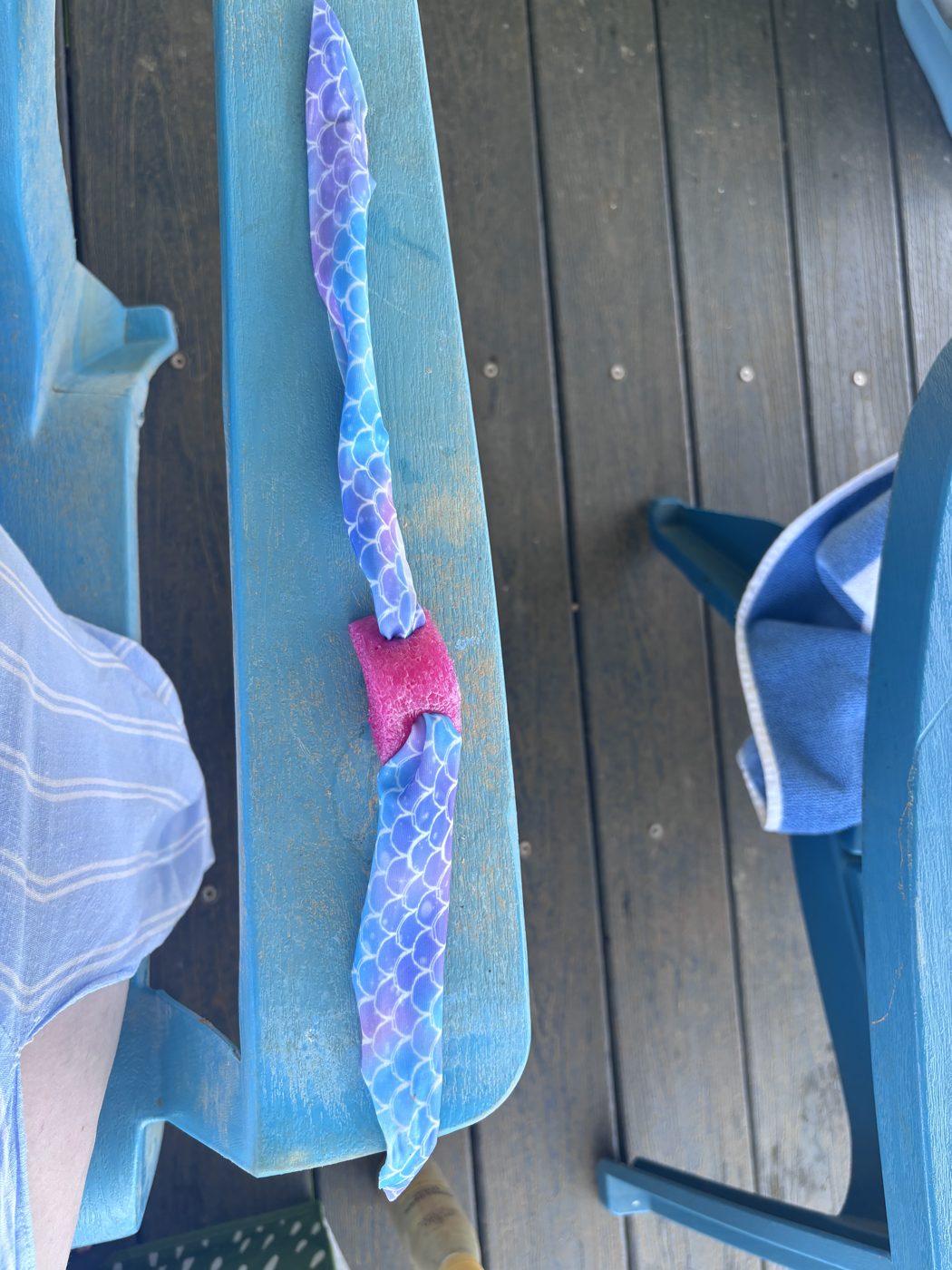 Goggle Bean threaded onto a mermaid-print goggle strap resting on a blue lake chair